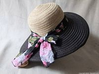 Three angles of a new cotton summer hat showing front, side, and top views with its floral scarf bow detail.