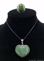 Ring and heart-shaped pendant necklace displayed on black bust stand showing front view of both items