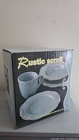 Photo of original box showing Rustic Scroll design with images of mug, medium and small plates