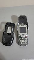 Samsung flip phone with black plastic case showing front and back sides of the items, status untested.