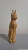 Side view of handmade wooden Sphinx cat statue showing its detailed facial carving and seated paw position.