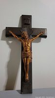 Front view of metal crucifix showing Jesus figure on cross