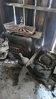 Photo of full old wood stove with ornate cast iron design, glass window door, and removable vent/grate on top.