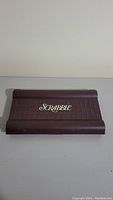 Closed brown plastic case with Scrabble logo showing exterior of portable game