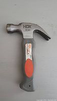 Top view of short hammer showing HDX branding, 8 oz marking, and orange-gray rubber grip handle.