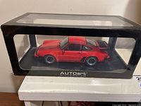 Side view of the red Porsche 911 Turbo 3.3 model inside the display box showing detailed paint and wheels.