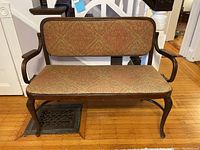 Front view showing entire bentwood settee with upholstered seat and backrest.