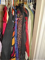 View of multiple women's clothing items hanging on a rack showing colorful and patterned garments.