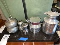 Wide photo showing full lot: Termica Express Italian espresso pot, salt and pepper shakers, and Royal Holland pewter cream and sugar set on counter.