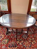 Full view of round table in room with glass top and carved wood base