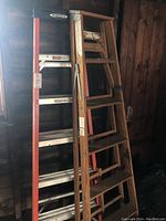 Photo showing both wooden and Werner fiberglass ladders standing side by side in a garage setting.