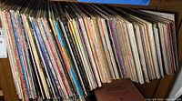 Photo of large collection of vintage vinyl records seen from side showing colorful, worn spines.