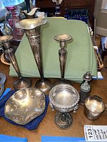 All sterling items arranged on a table: two candlesticks, bud vase, tray, compote, cup, shakers, napkin ring