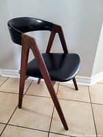 Side angle showing angled teak frame and curved vinyl backrest