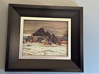 Full view of the framed artwork showing the entire winter village scene painting with wood frame.
