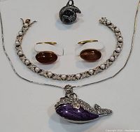 Front view of costume jewelry lot showing bracelet, earrings, pendant necklace, and ring neatly arranged