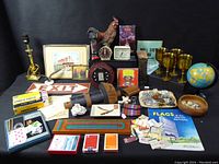 Photo showing entire lot with various vintage household and decorative items including goblets, globe, framed pictures, exit sign, poker chips, clocks, and more.