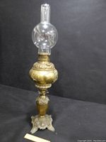 Full view of the fully assembled Victorian parlor hurricane lamp, showing the ornate brass body, decorative embossed details, and new clear glass chimney on top.