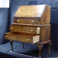 Full view of vintage secretarial desk showing open drawers and cabriole legs.