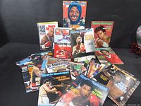 Photo showing a spread of about 17 vintage Sports Illustrated magazines with various sports covers, predominantly boxing and basketball athletes.