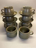 Full set with 6 stacked cups on saucers and creamer and sugar bowl at front
