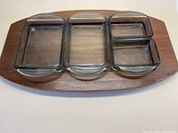 Full top view of teak tray with five fitted smoky grey glass dishes showing size and arrangement