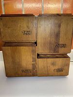 Four wooden kitchen canisters grouped together showing the front with dual-language labeling.