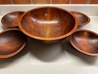 Front angle showing one large bowl with five smaller bowls nested inside, all with smooth brown finish and mid-century style