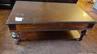 Top view of rectangular brown wood coffee table showing wood grain pattern with some surface wear and minor scuffs.