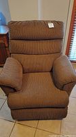 Front view of brown reclining lounge chair showing padded armrests and cushioned seat and back
