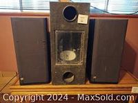 Front view of the JBL speakers and bass box showing the three pieces together in a room.