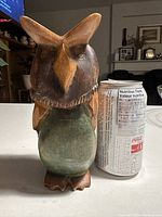 Photo of front side of carved wood owl with soda can for size comparison