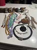 Assorted bracelets, necklaces, rings, and pendants displayed on a flat surface