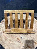 Front view of the wooden book stand showing vertical slats and front ledge