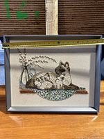 Framed cat embroidery with measuring tape showing approximately 21 inches width.