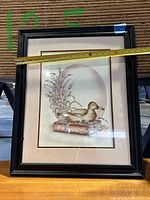 Framed duck print artwork with a measuring tape showing length near 24 inches.