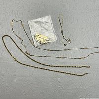 Four necklaces laid on fabric background showing various chain styles