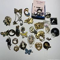 Assorted costume jewelry pins arranged flat on a white background showing varying designs and materials.