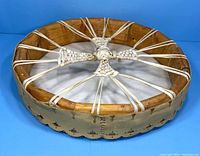 Side angle showing wood frame, rawhide lacing, and drum thickness