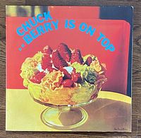 Front cover of Chuck Berry 'Berry Is On Top' red vinyl album showing dessert image and blue text