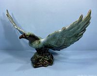Front left view of the Blue Mountain Pottery eagle figurine showing wings spread wide and textured base.