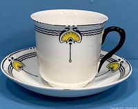 Porcelain Shelley Art Nouveau Norman shape cup and saucer set with yellow and black fan design. Cup flares slightly at top, has black handle. Saucer matches pattern.