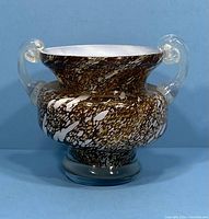 Front view of the vintage Murano glass two handled vase showing the mottled pattern on the body and clear glass handles.