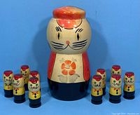 Full set of 11 nesting dolls including the large cat doll and 10 smaller kitten dolls arranged around it.