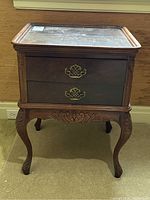 Full front view of antique mahogany end table showing two drawers with brass handles, cabriole legs, and carved apron.