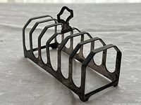 Side angle showing six curved silver slots and a decorative handle on top.