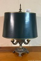 Full view of lamp with dark green shade and metal ornate base