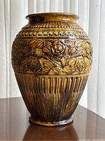 Front view of Weller Pottery floor vase showing floral relief decorations and brown-yellow glaze.