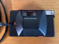 Top and front view of the Pentax PC35 AF camera showing the flash, autofocus window, and Pentax branding.