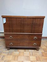 Front view of vintage wooden double cedar chest showing two drawers and some wear marks